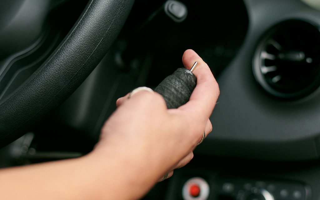 A woman's hand sits on a hand control for a car