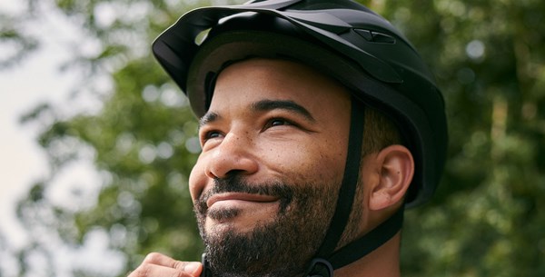 A man tightens his bicycle helmet