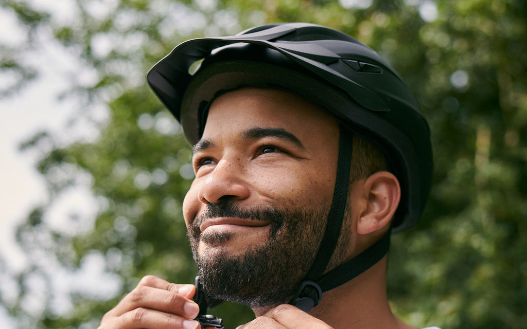 A man tightens his bicycle helmet