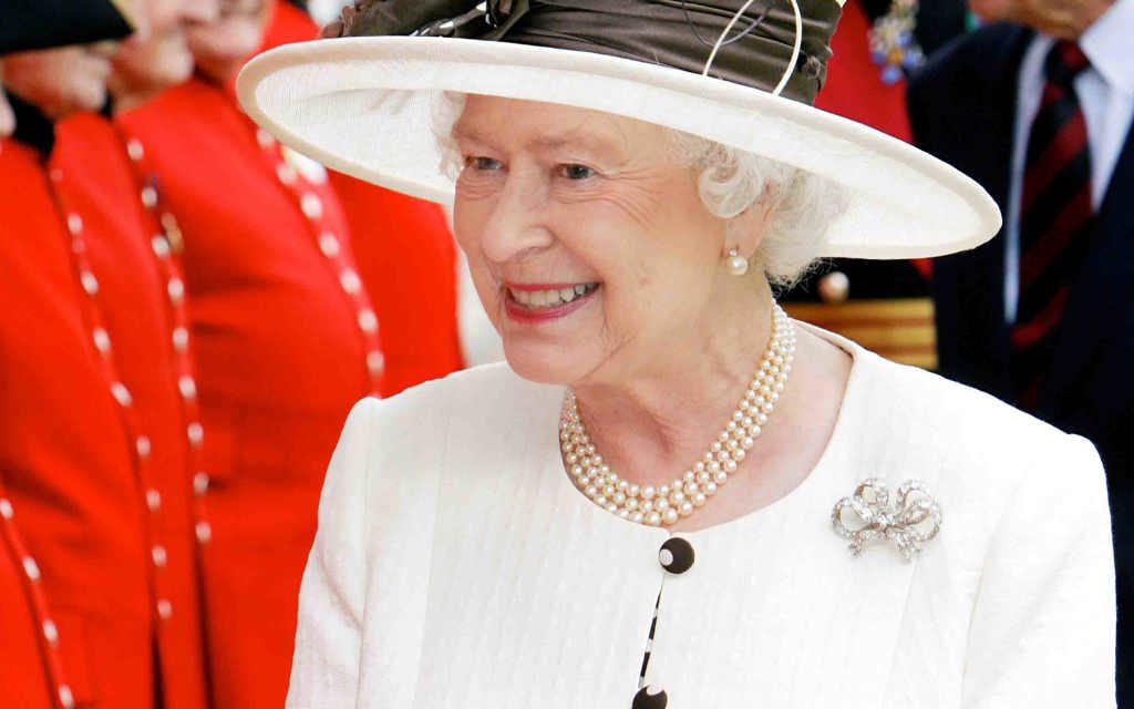 Her Majesty The Queen smiling and walking