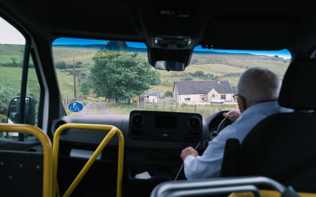 Community transport driver, driving an accessible mini-bus through rural Northern Ireland.